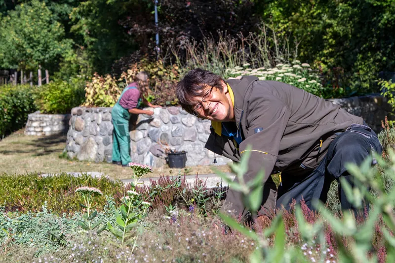 Eine Person ist bei der Beetpflege auf dem Lehrgelände des ÖkoNet Betriebsteils Arbeit & Ökologie zu sehen.