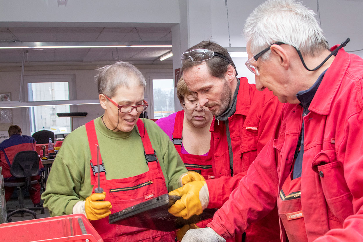 Anleiter:innen besprechen die Zerlegung von Elektrogeräten im Team
